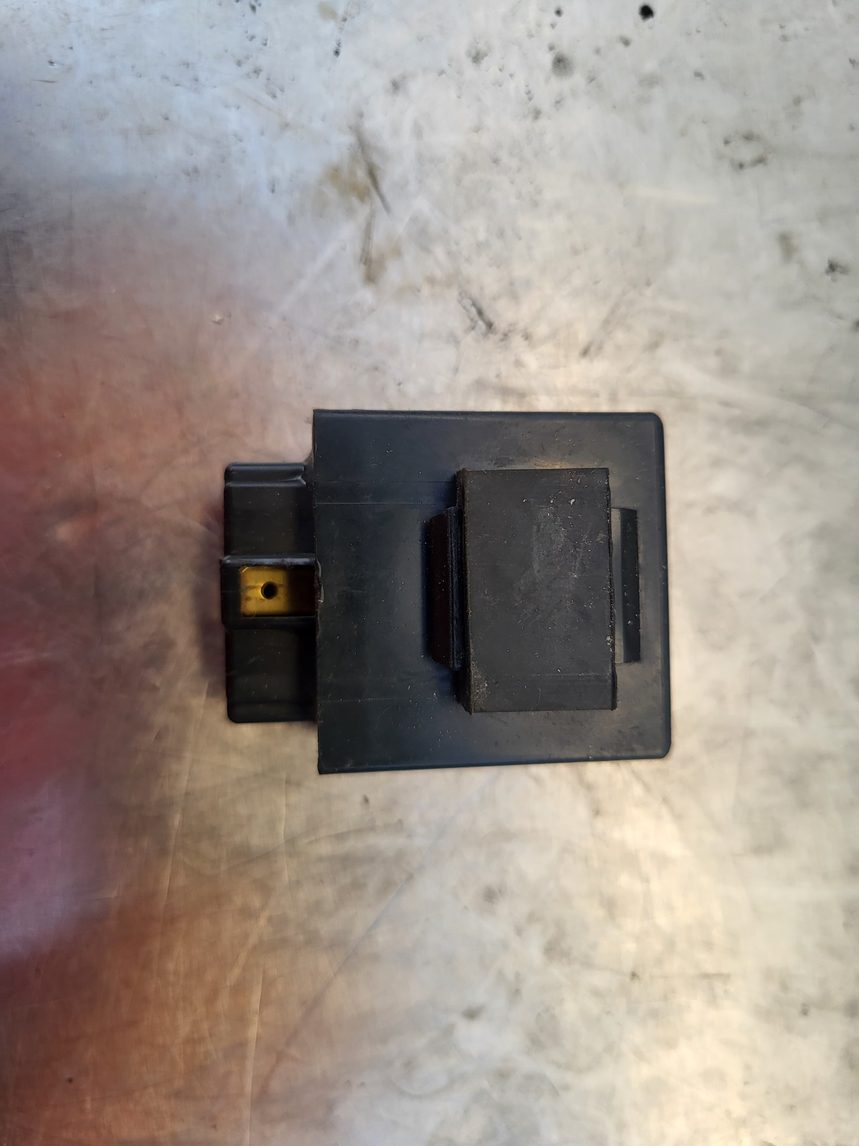 Top view of the black rectangular electrical unit with a multi-pin connector visible