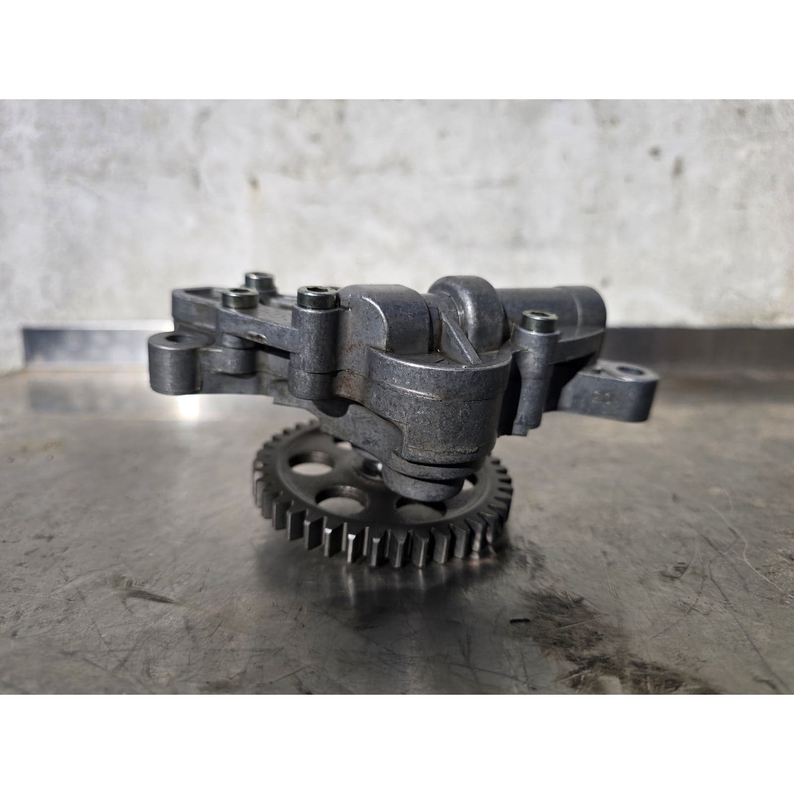 Side view of the Ducati engine oil pump assembly with drive gear.