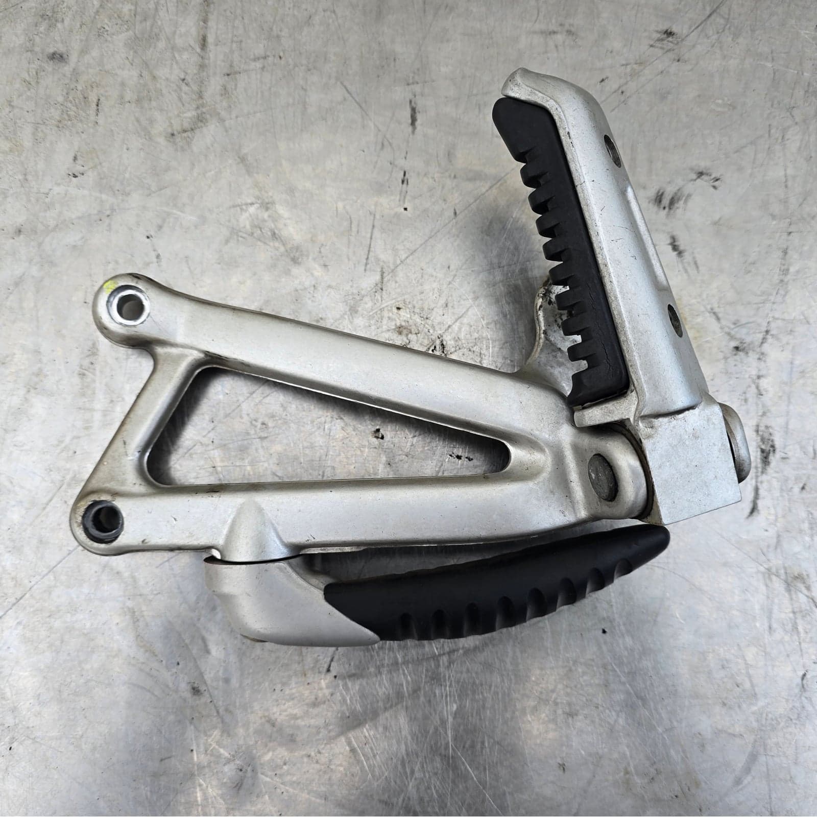 Overview of the Ducati right passenger footpeg hanger and footrest assembly.